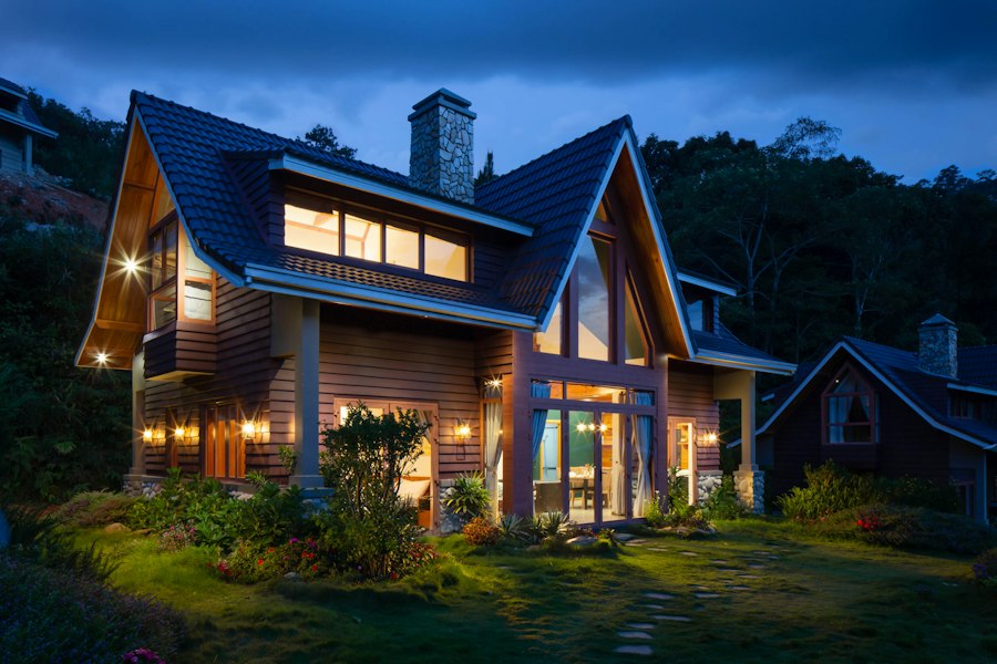 A detached house at dusk with the lights on